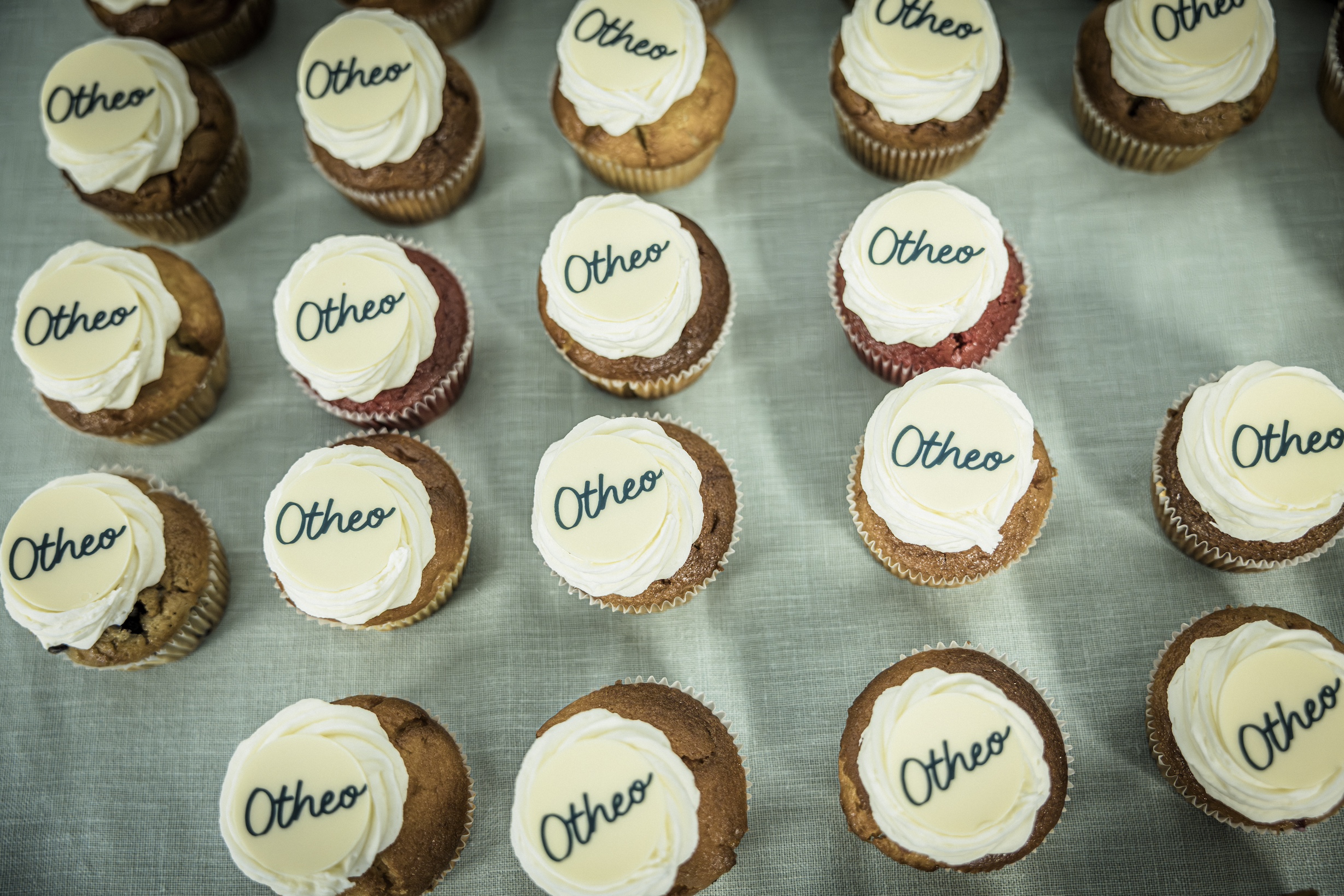 Een heerlijk gebakje als dessert. De rij cupcakes met logo 'Otheo' oogt aantrekkelijk.