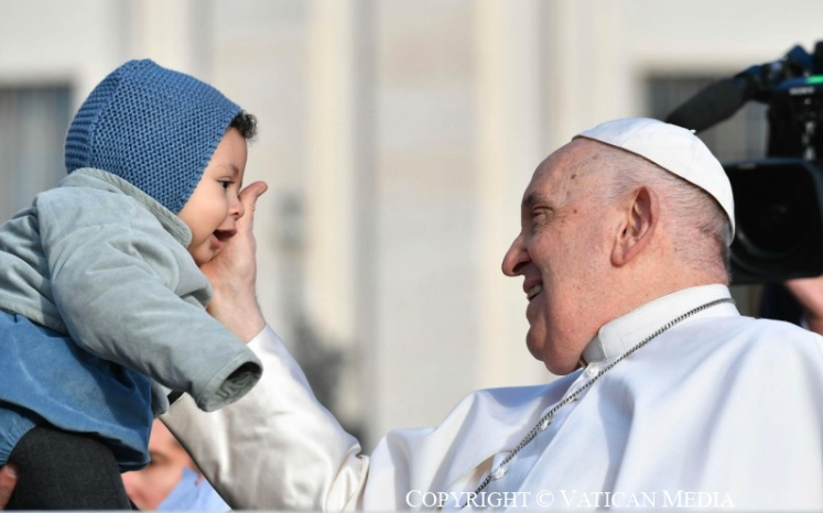 Paus Franciscus begroet kind