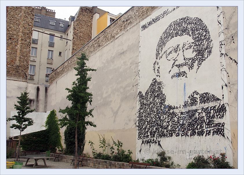 Abbé Pierre in graffiti getekend op een witte muur.
