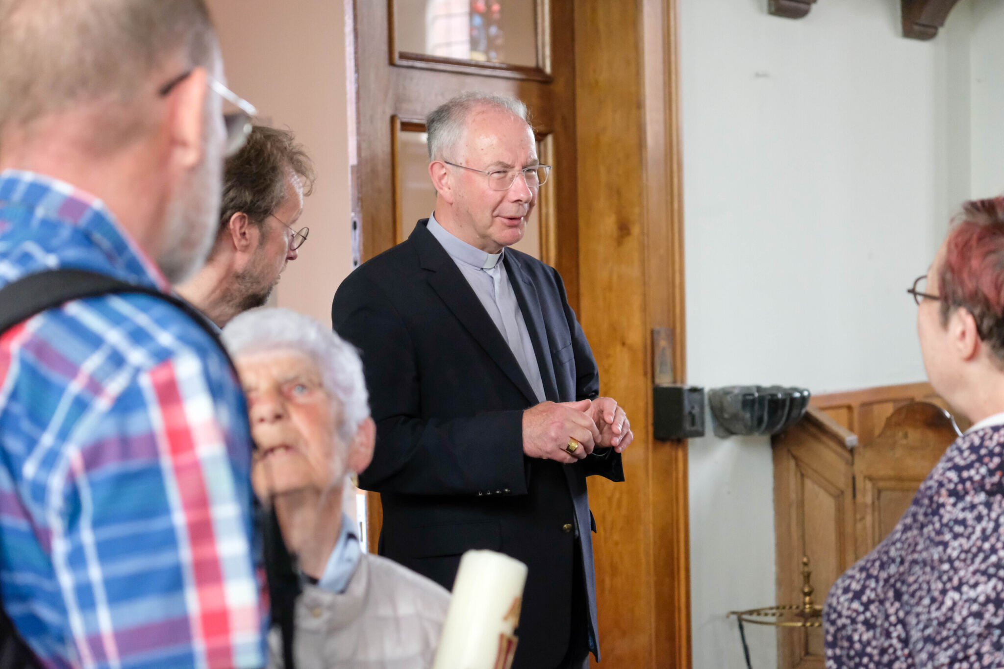 Hulpbisschop Koen Vanhoutte in gesprek met parochianen in de kerk van Heffen.