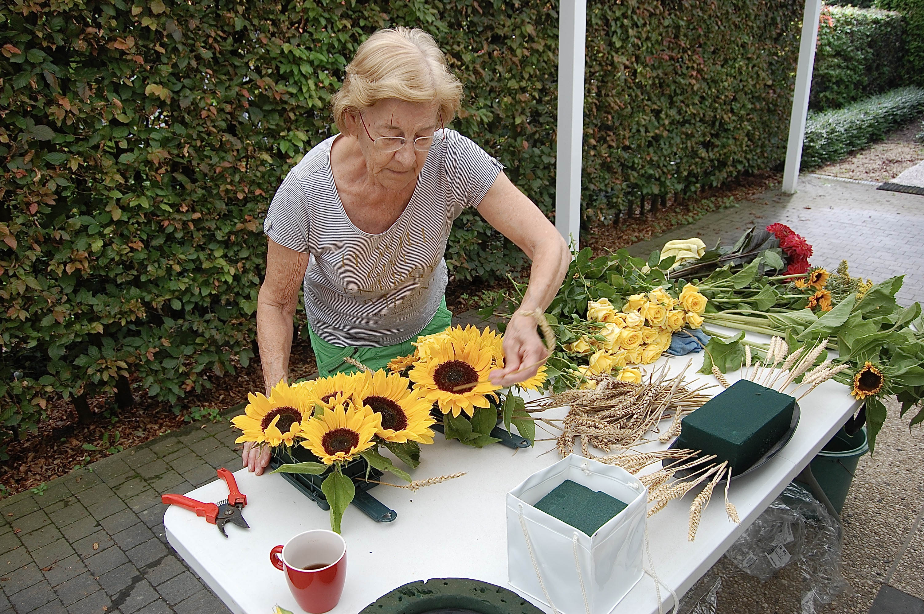 Lieve, een van de vrijwilligers, staat in voor de bloemen en versiering van de kerk.