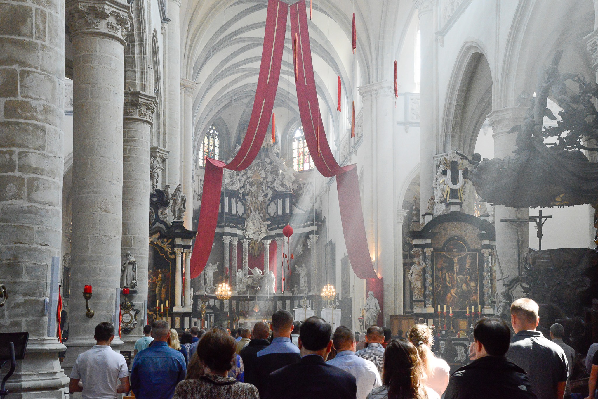 Sint-Andrieskerk Antwerpen, Pinksteren 2024. Vanaf de koepel hangen rode doeken in guirlandes naar omlaag.