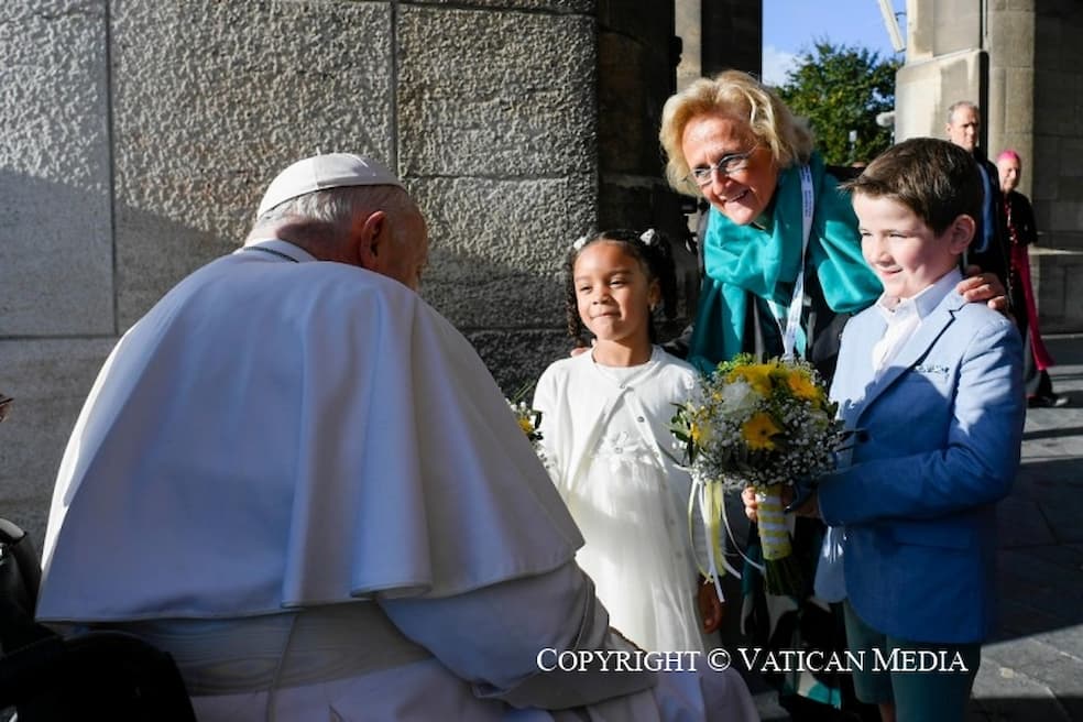  Martine Motteux en twee kinderen wachten de paus op en bieden hem gele bloemen aan