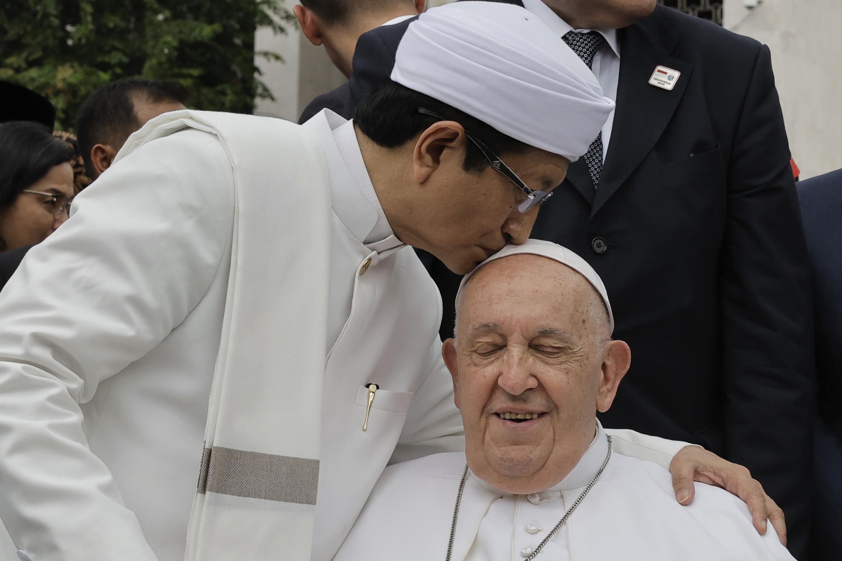 Grootimam Nasaruddin Umar kust paus Franciscus op het hoofd. De paus heeft de ogen gesloten en is verrast door het gebaar.