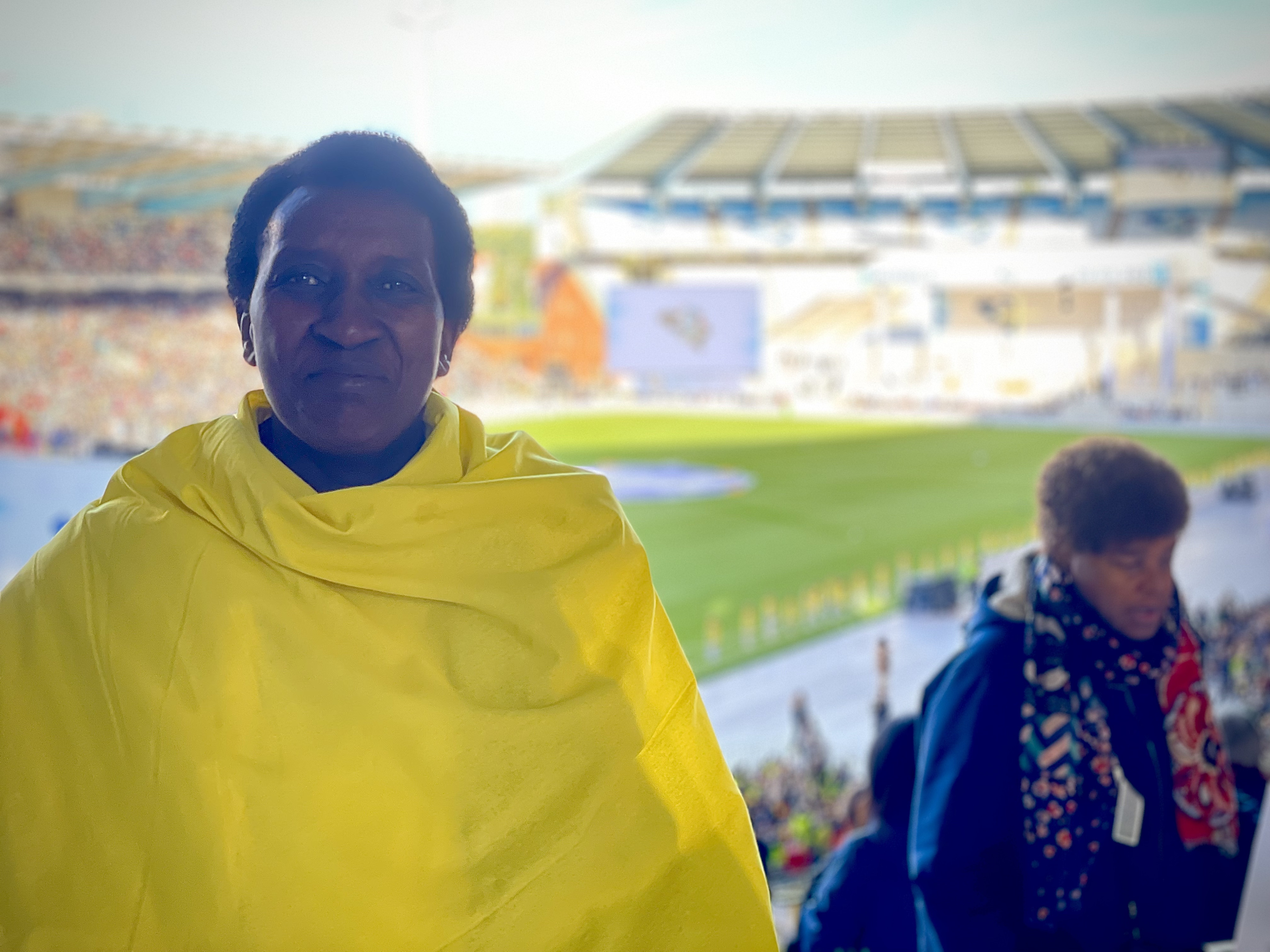 Een vrouw in Vaticaanse kleuren gehuld poseert voor de foto in het Koning Boudewijnstadion, vlak voor de mis met de paus begint.