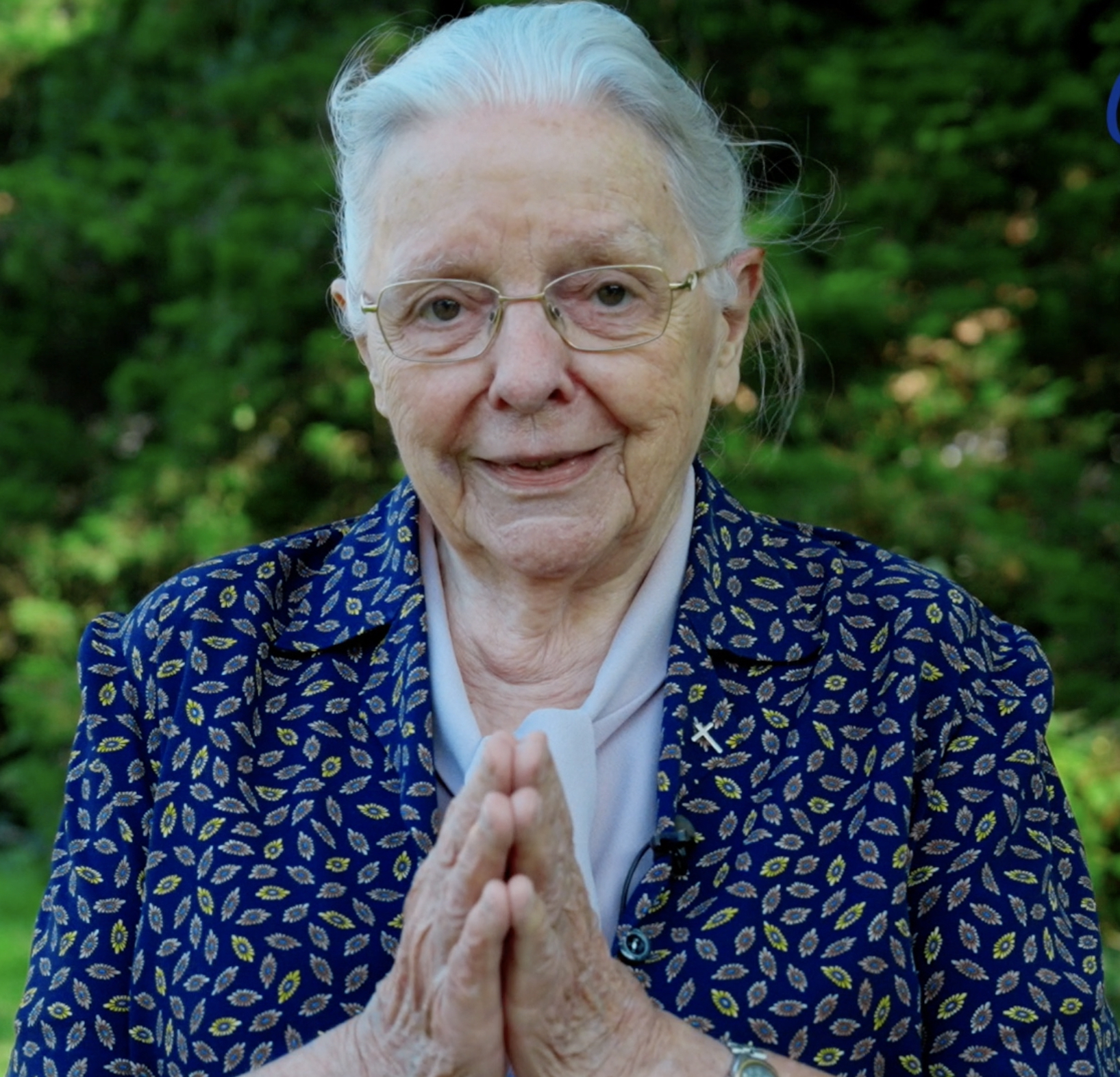 Jeanne Devos, handen gevouwen in een groet: 'Namaste'