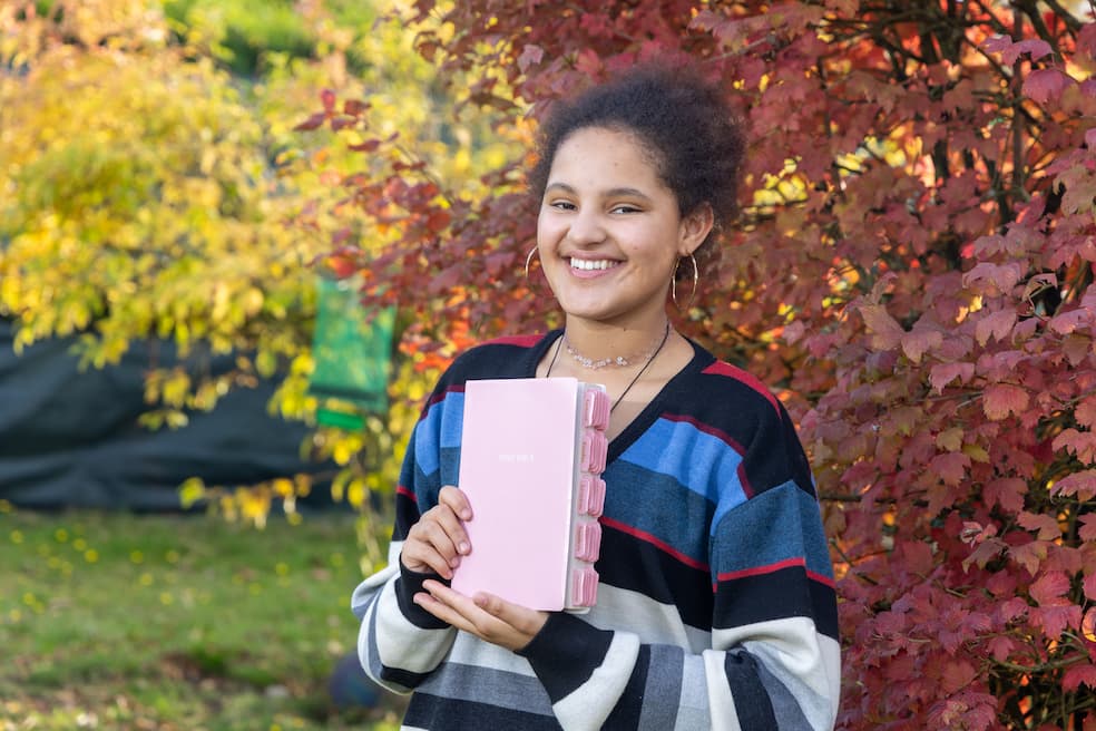 Trots toont Sikudhani haar roze Bijbel. Elk boekonderdeel kreeg een extra roze labeltje.