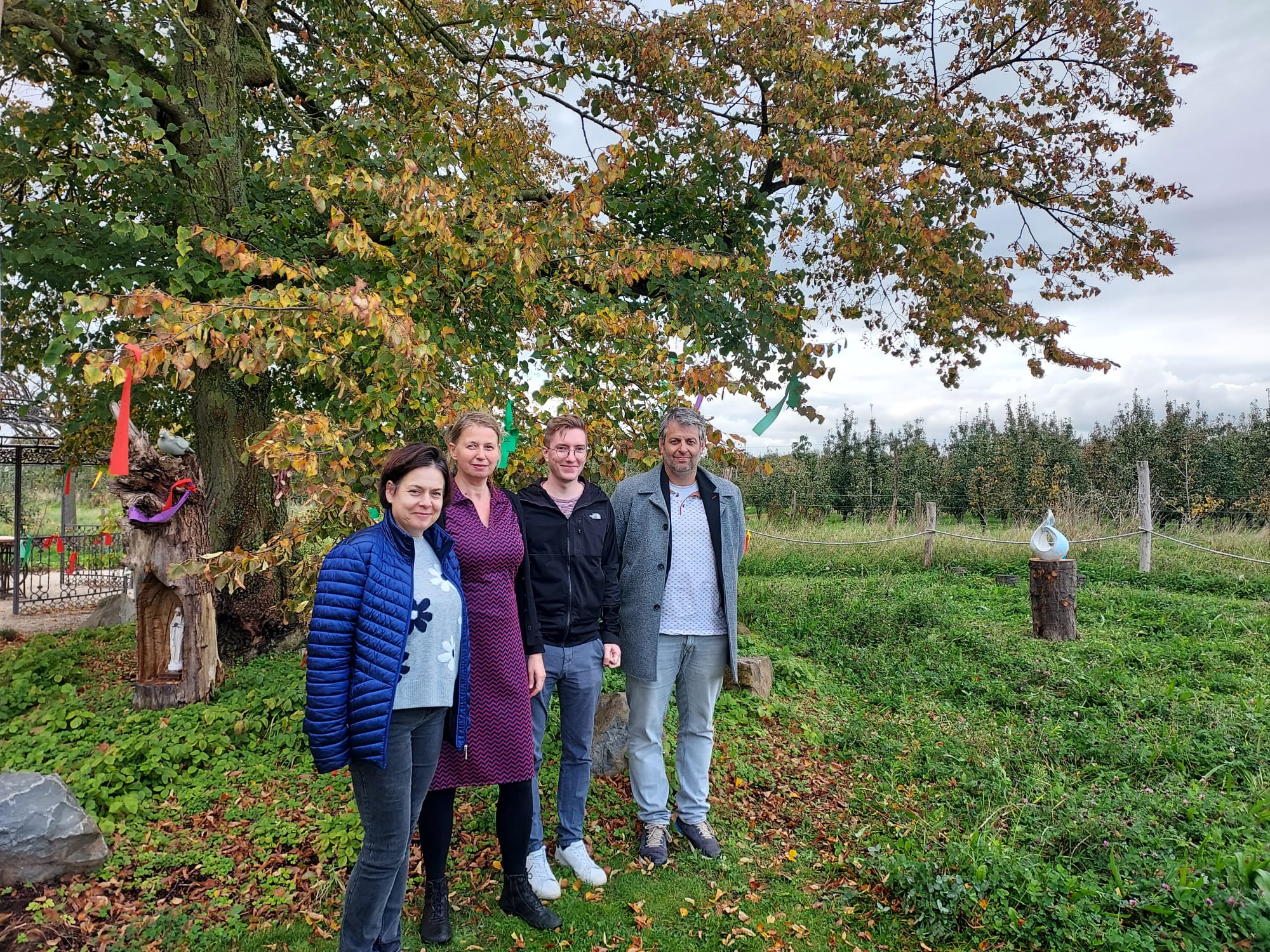 Voor de lindeboom op de Pleisterplek staan pastores Hilde Schmitz, Ann Verscuren en Jonas Sanen, naast algemeen directeur Bert Plessers.