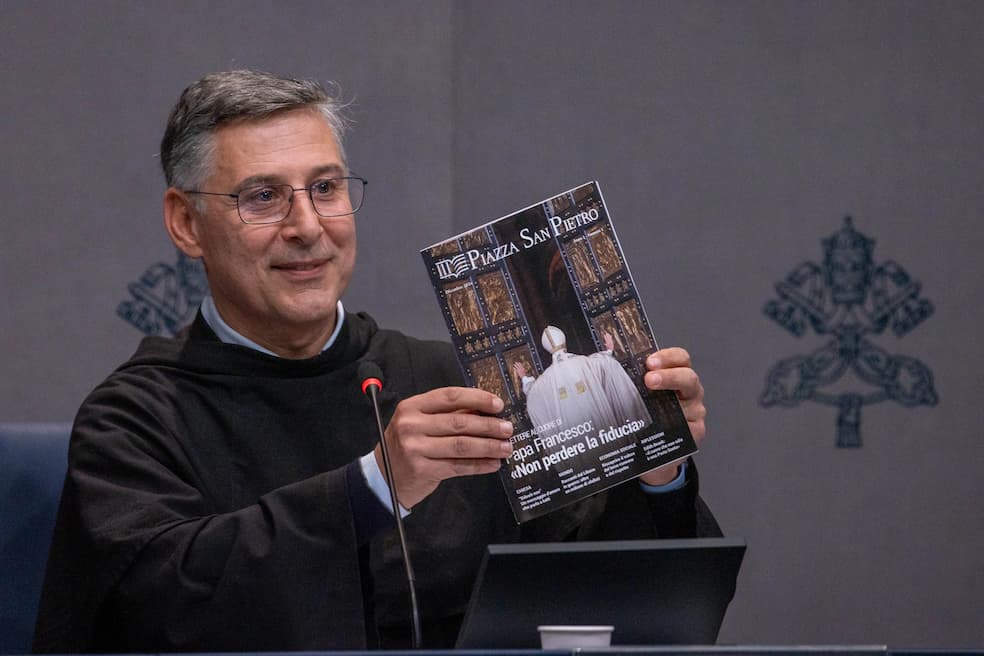 Pater Enzo Fortunato, communicatiedirecteur van de Sint-Pietersbasiliek, houdt een exemplaar omhoog van het eerste nummer van het nieuwe maandelijkse tijdschrift Piazza San Pietro