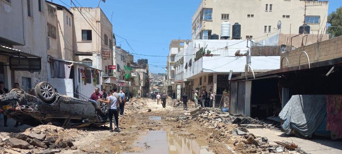 Zicht op een straat in het vluchtelingenkamp van Jenin, waar veel vernieling is aangebracht. Een auto ligt op de kop.