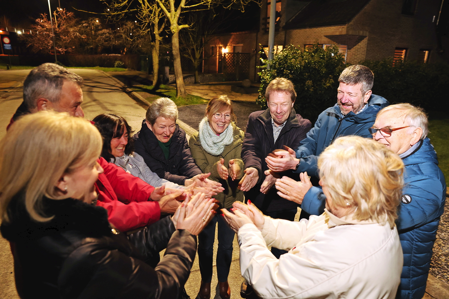 Negen buren druppelen rond 20 uur naar buiten voor het dagelijkse applaus. ‘Dit is de tofste straat van Lokeren’, klinkt het. ‘Zeg maar Groot-Lokeren!’, zo wordt meteen gevat aangevuld. © Kristof Ghyselinck