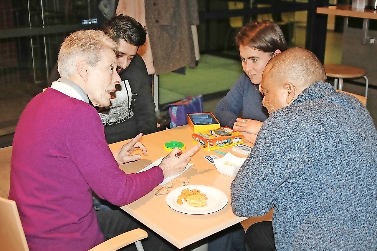 Anderstalige vluchtelingen en autochtone Merchtemnaren ontmoeten elkaar aan de ‘conversatietafel’. © Renaat Schoukens