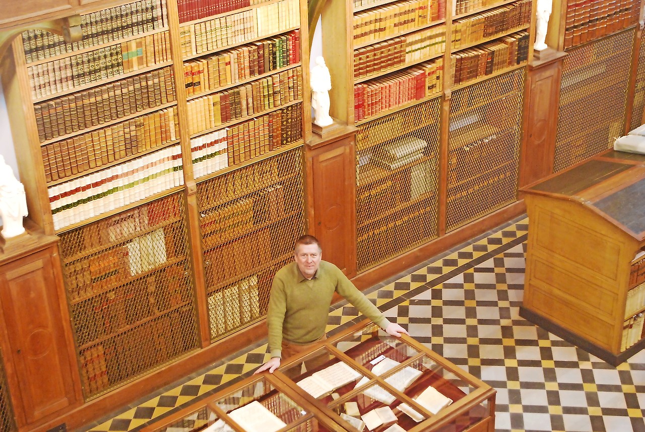 Gert Van Kerckhoven in de imposante bibliotheek van de abdij van Bornem. © Filip Ceulemans