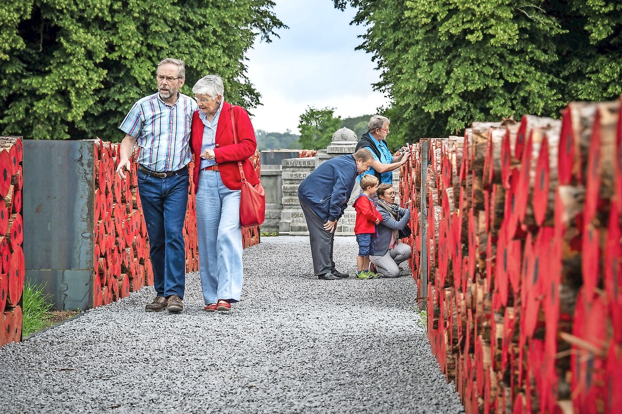 Bezoekers lopen in een ‘loopgraaf’ van gestapelde boomstammen. © Toerisme Vlaams-Brabant