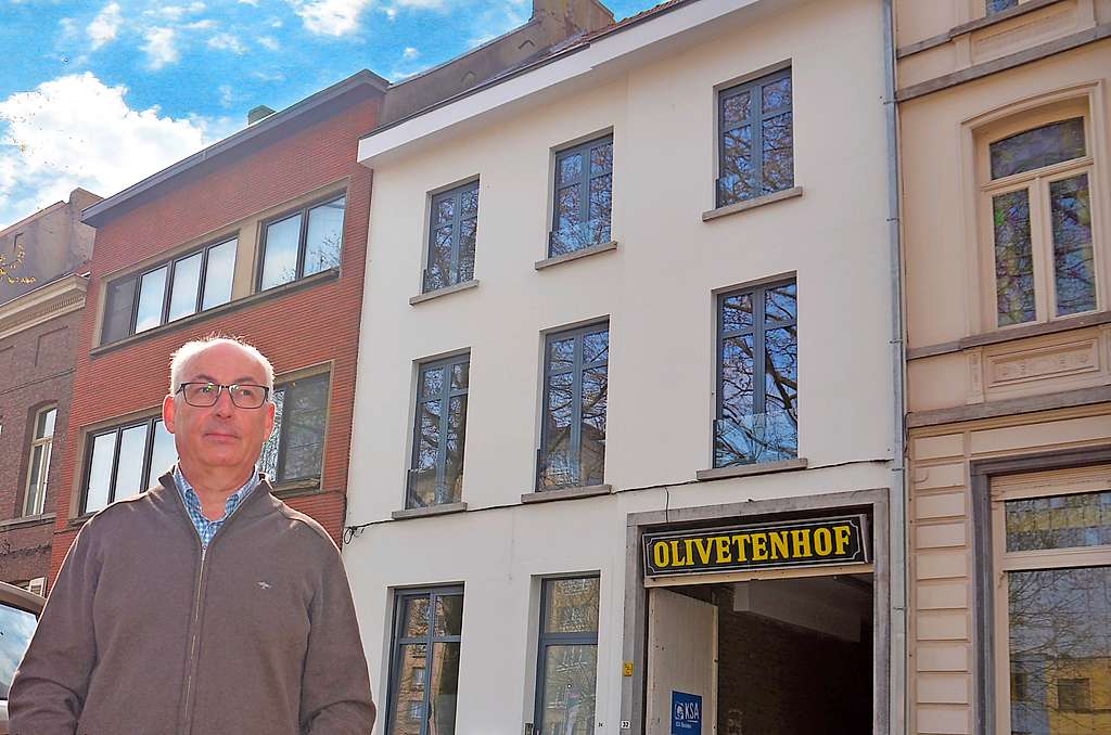 Karl De Witte toont trots het recentelijk gerenoveerde pand aan de ingang van het Olivetenhof in Mechelen. © Tony Dupont