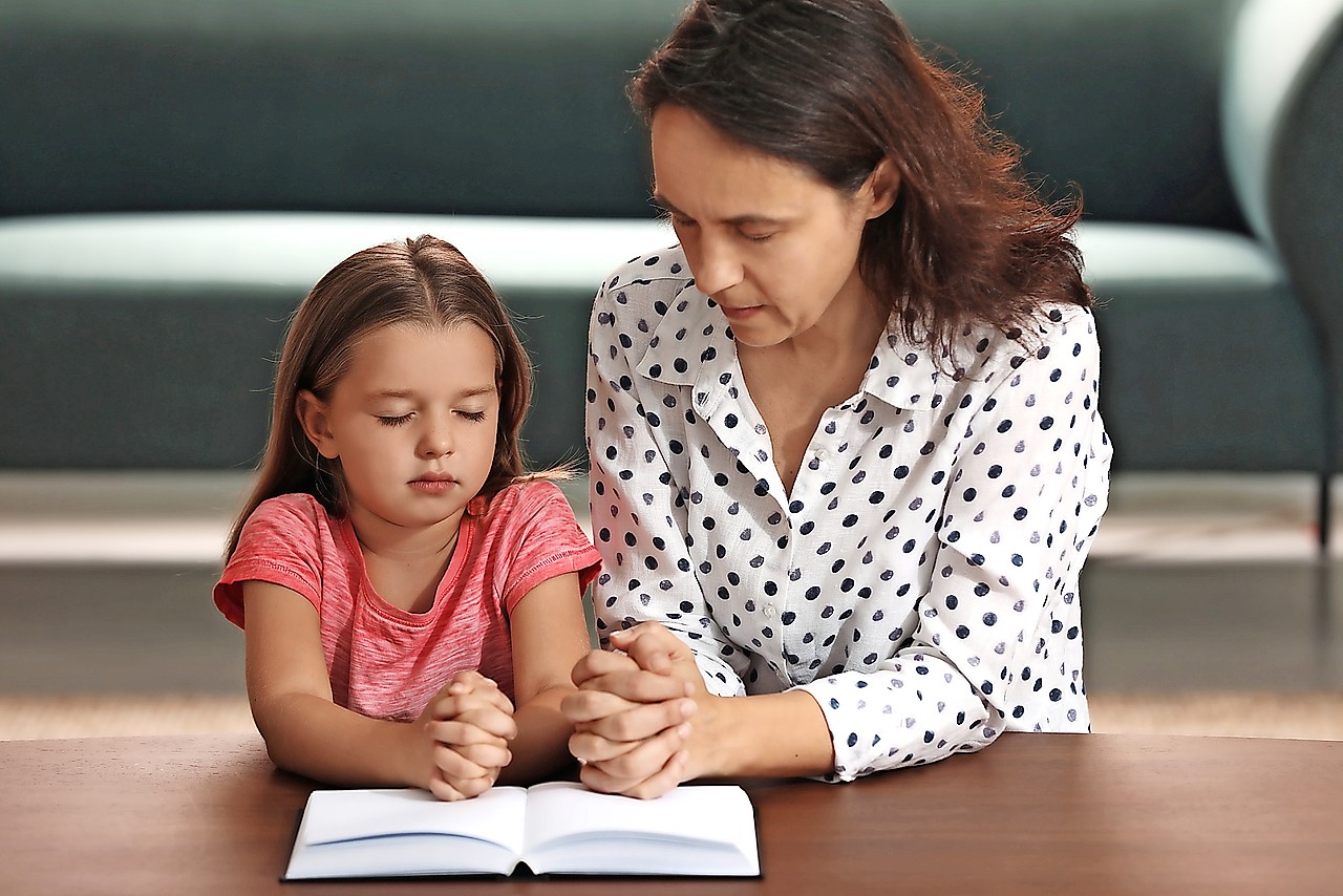 Ouders kunnen thuis een moment inbouwen om te bidden met hun kinderen. © Shutterstock