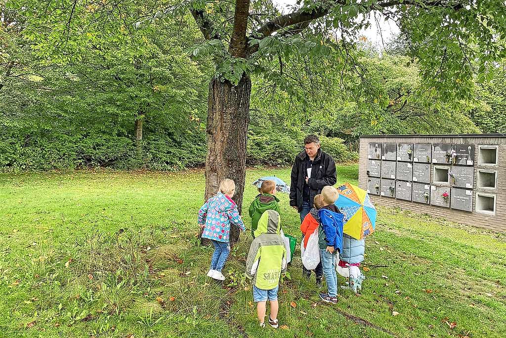 Op de begraafplaats toont Tomas Bruyland kinderen de urnengalerij. © vzw Lucas for Life