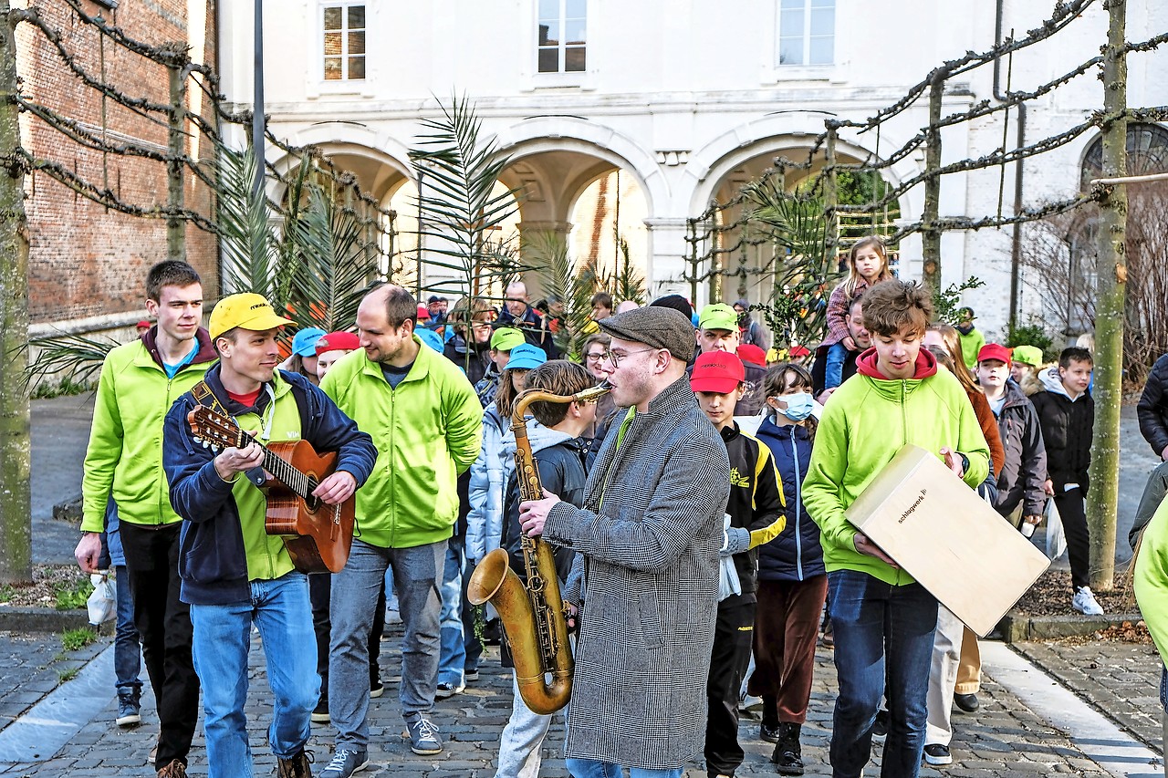 De vormelingen en hun begeleiders trekken in een muzikale palmprocessie naar de basiliek. © Laurens Vangeel