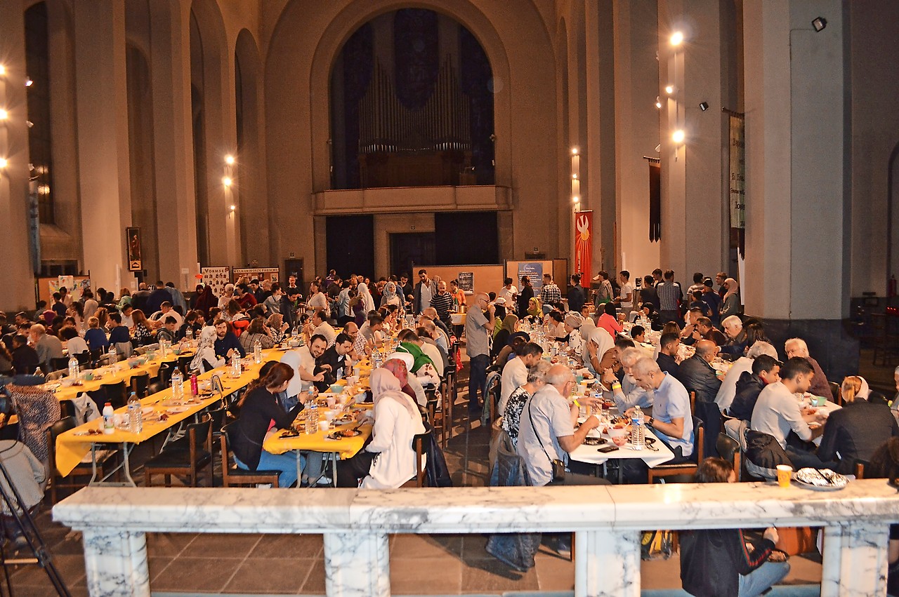 Veel volk aan tafel in de kerk bij het verbreken van de islamitische vasten © Erik De Smet