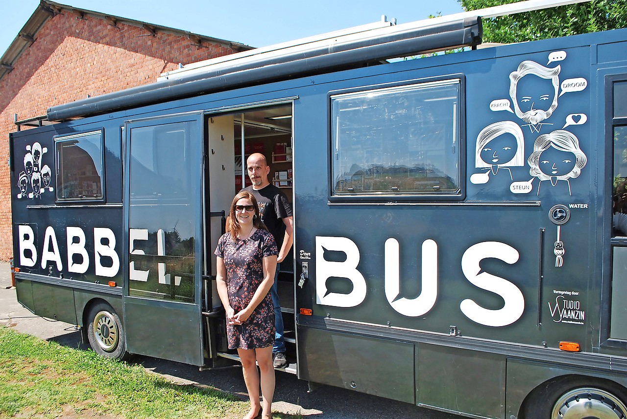 Eva Gilis en Paul poseren bij de Babbelbus die ze in enkele weken tijd gebruiksklaar maakten. © Filip Ceulemans