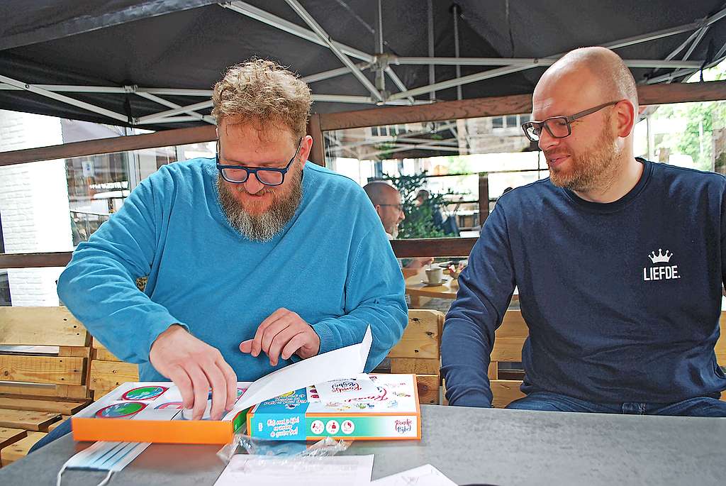 Jan Caljon ontdekt het spel dat hij mee ontwikkelde. Dries de Bakker kijkt toe. © Filip Ceulemans