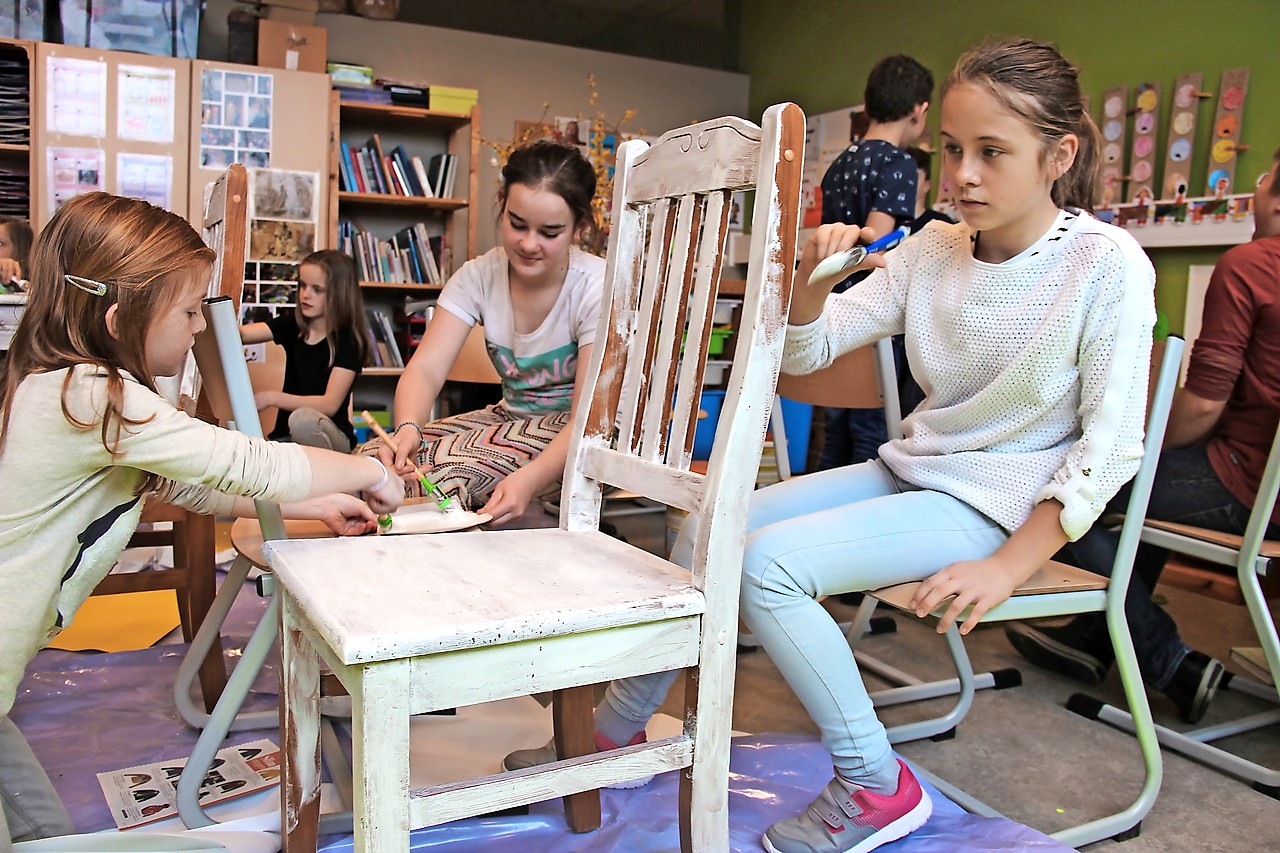 Leerlingen van Barthel schilderen stoelen voor Witte Donderdag. © Liselotte Anckaert