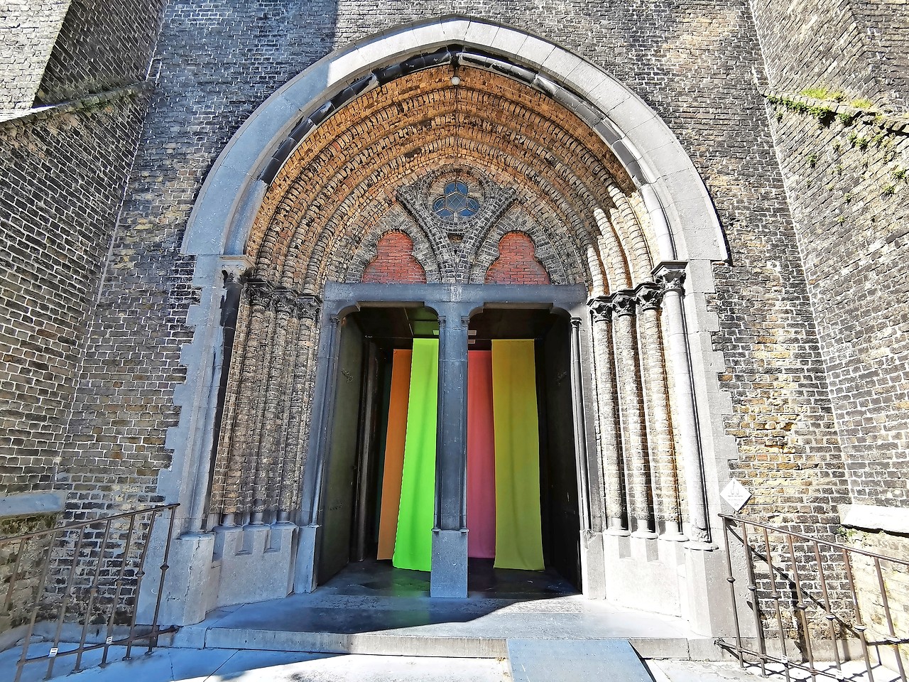 Bij het betreden van de kerk laveert de bezoeker tussen kleurrijke doeken. © Ann Benoot