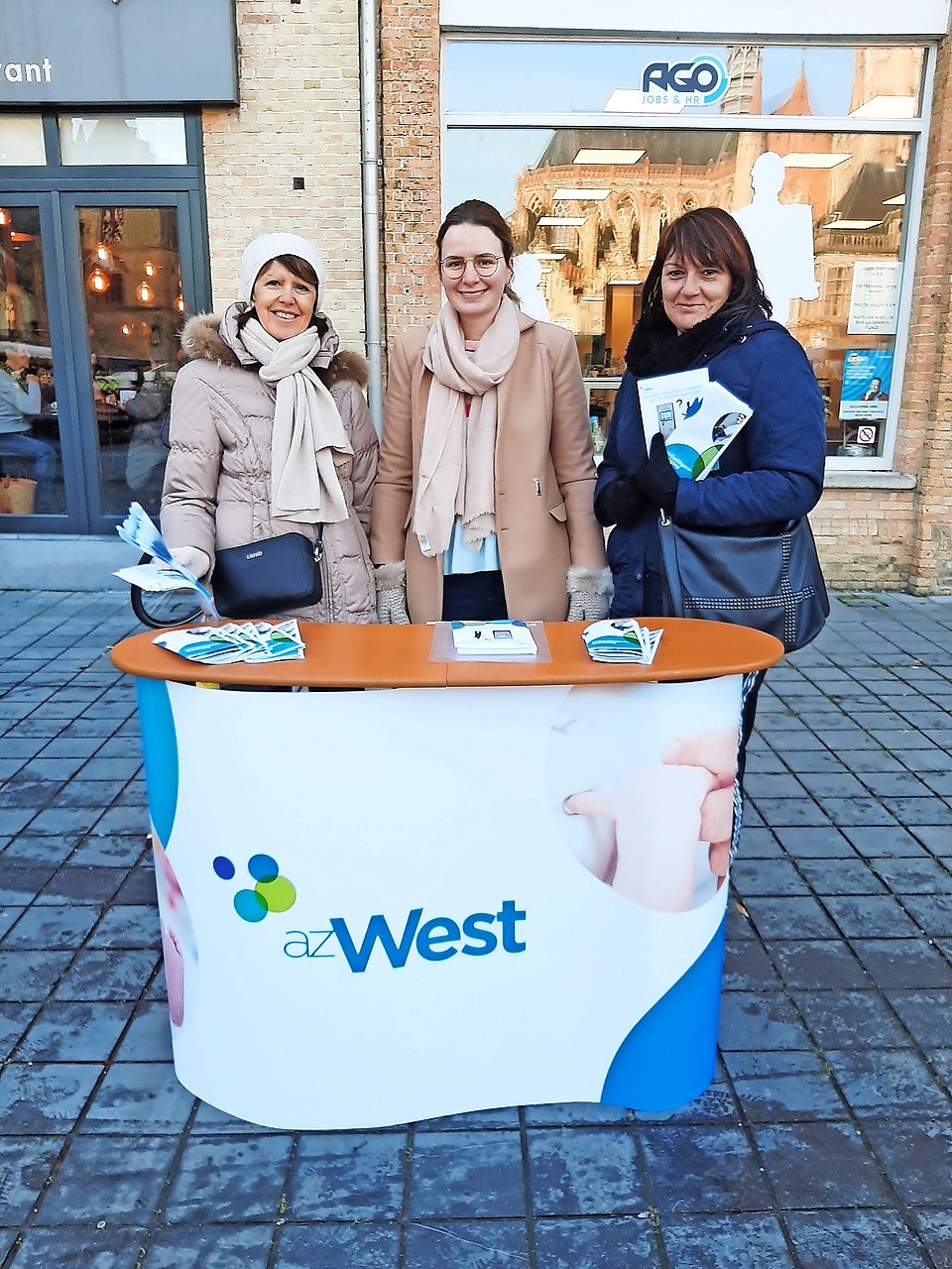 Op de markt in Veurne werft Bieke Roose (midden) nieuwe vrijwilligers. © Bieke Roose