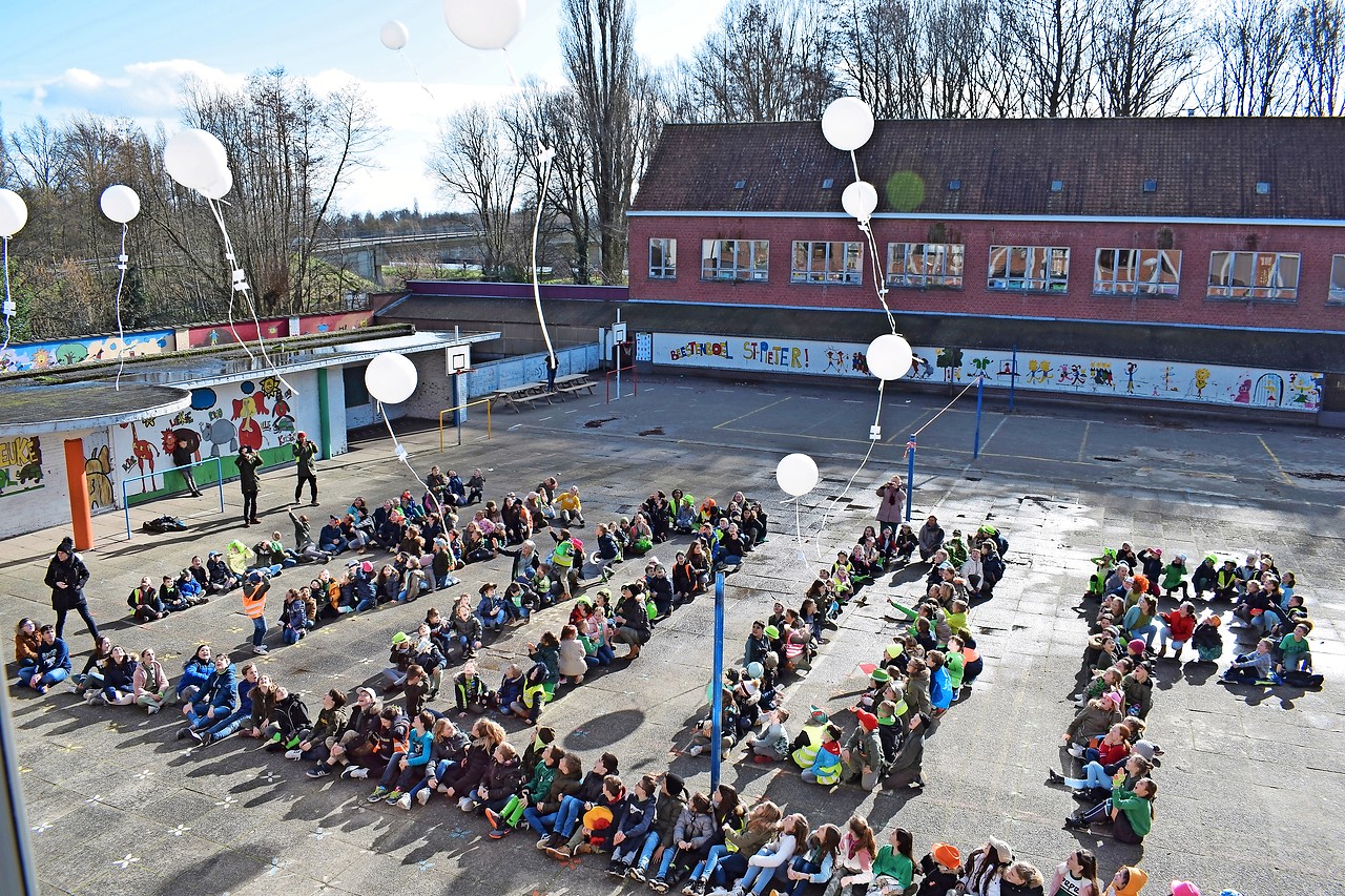 Kinderen uit Izegem laten witte ballonnen op als teken van hoop. © Michiel Van Mulders