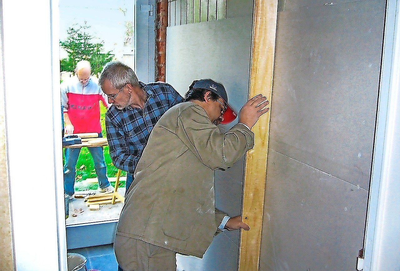 Vrijwilligers steken de handen uit de mouwen bij het opknappen van een huis. © vzw ’t Huis-werk