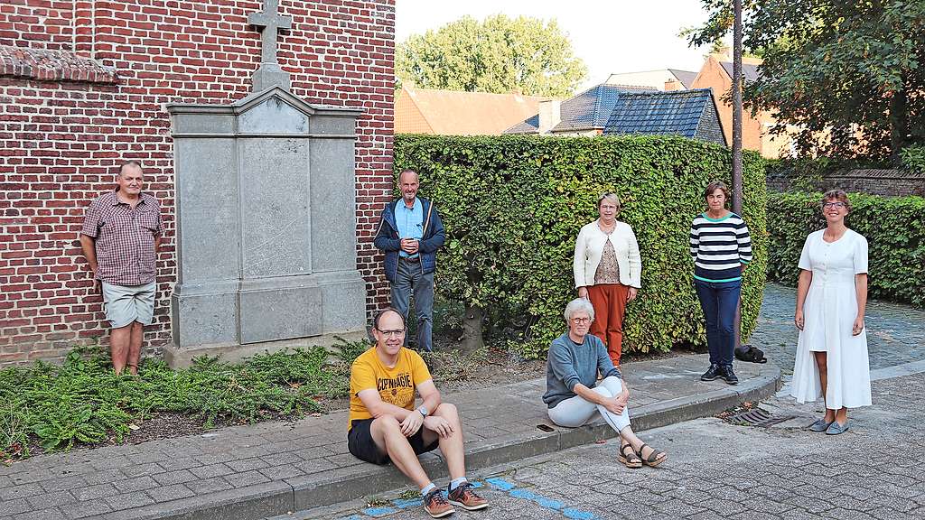 De initiatiefnemers bij de gedenkplaat voor de overleden benedictinessen aan de Sint-Brixiuskerk. © Heemkundige kring