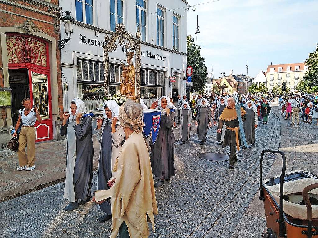 In de processie dragen enkele vrouwelijke bedevaarders het miraculeuze beeld van Onze-Lieve-vrouw-van-Blindekens mee. Bedelaars en zieken smeken om hulp. © Matthias Degraeve