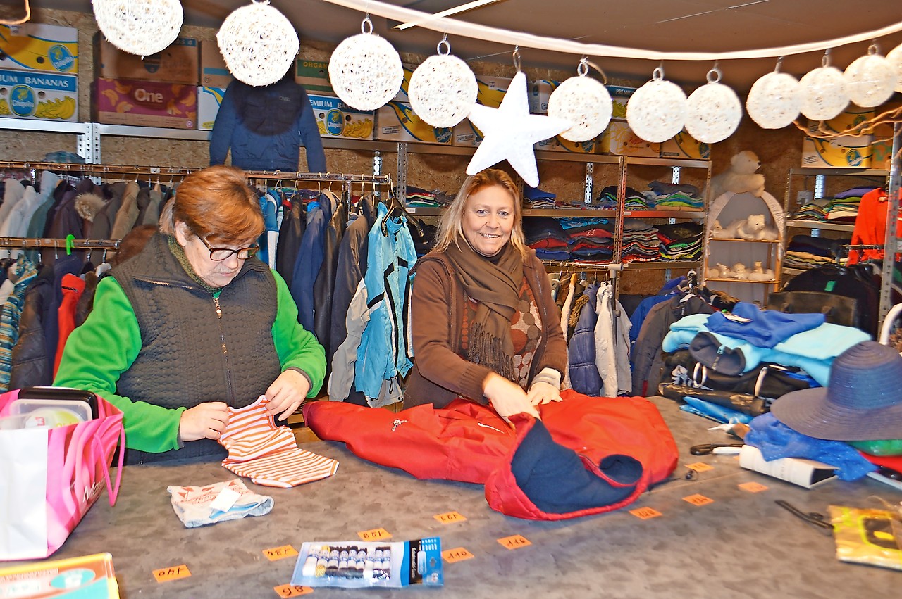 Vrijwilligers sorteren kleren in de loods van De Tondeldoos. © Bertrand Goethals