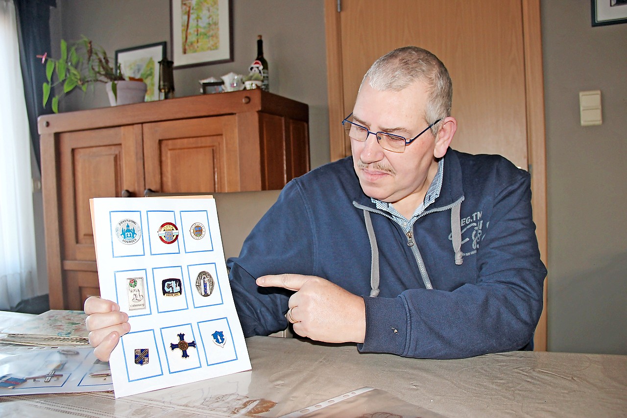 Martin Van Goethem laat met fierheid een speldje van het bisdom Gent zien. © Liselotte Anckaert