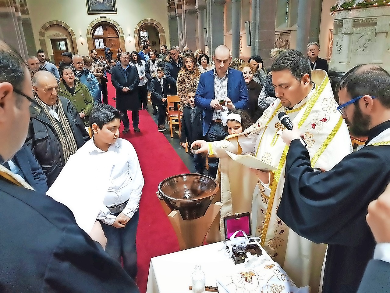 Priester Thomas Habbabé doopt in de Sint-Jozefkerk in Rapertingen. © Thomas Habbabé