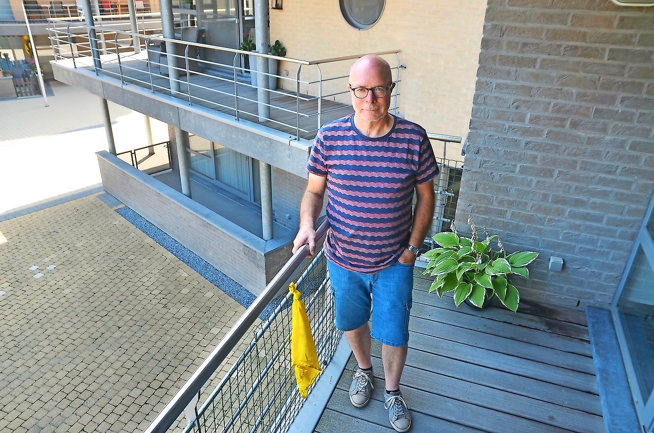 Jean Aerts knoopt een gele zakdoek, als symbool voor Werelddementiedag. © Tony Dupont