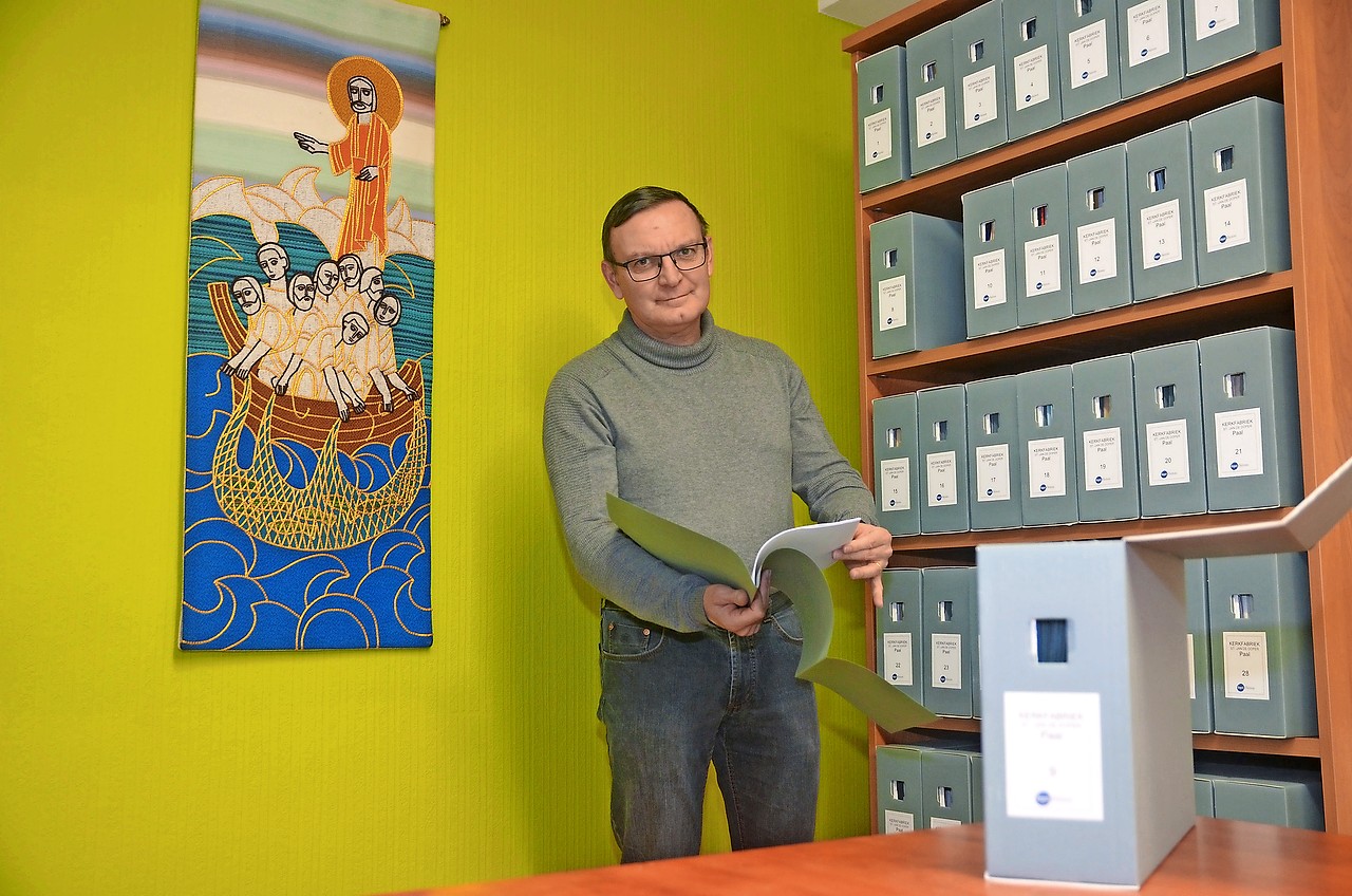 Johan Robrechts bij het archief van kerkfabriek en parochie, opgeslagen in zuurvrije enveloppes en dito dozen. © Tony Dupont