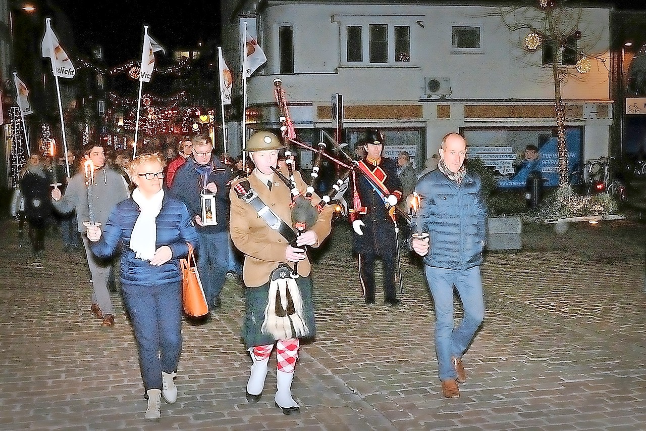 Een doedelzakspeler kondigt de komst aan van het Vredeslicht. Tony Achtergael (achterin rechts) is opgetogen. © Jos Collaer