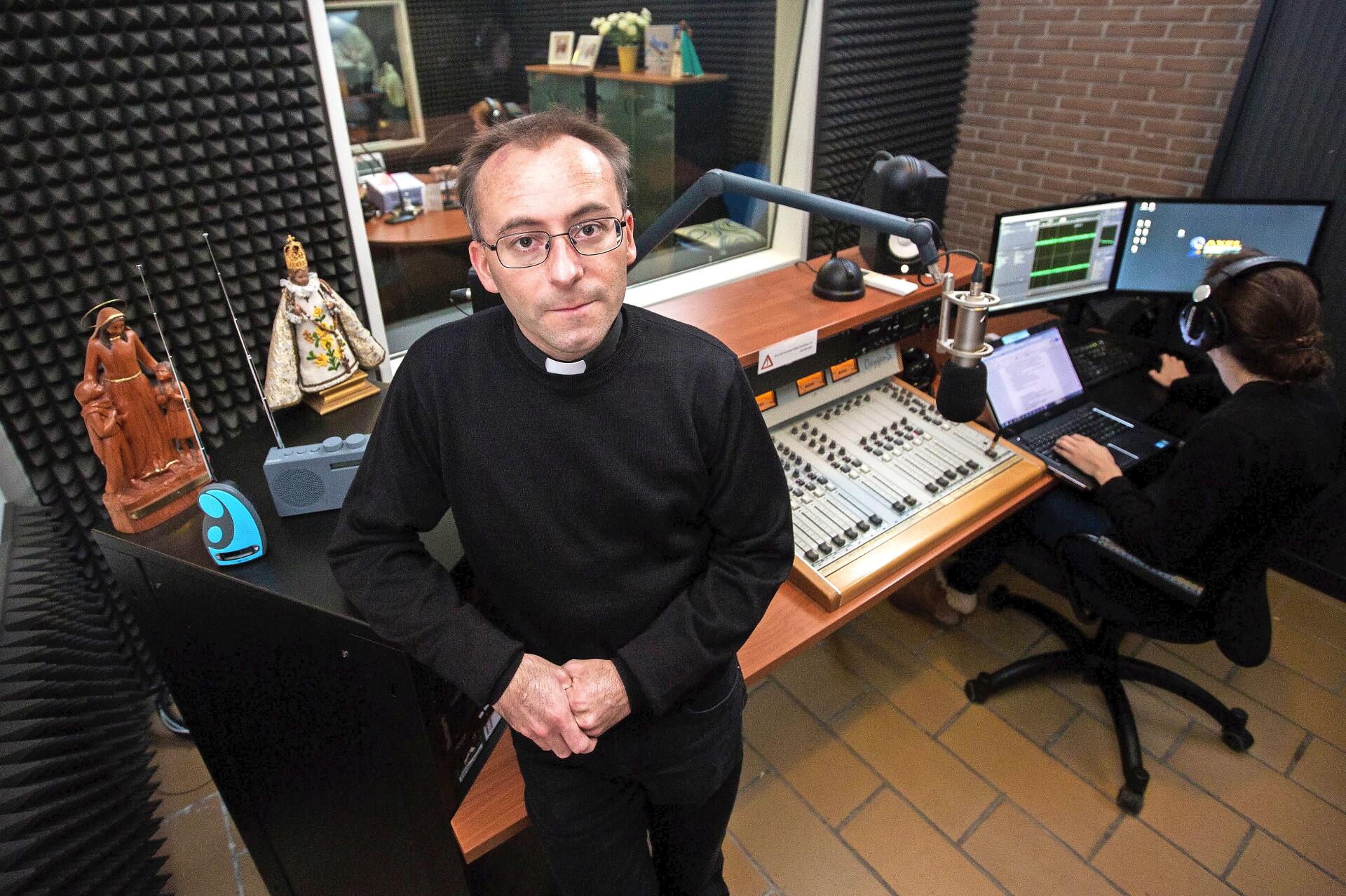 Priester Karlo Tyberghien in de studio van Radio Maria met aan de elleboog DAB+ontvangers. © Mine Dalemans