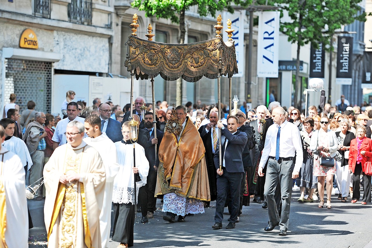 In een drukke Antwerpse winkelstraat draagt mgr. Bonny de monstrans tijdens de sacramentsprocessie. © Selina De Maeyer