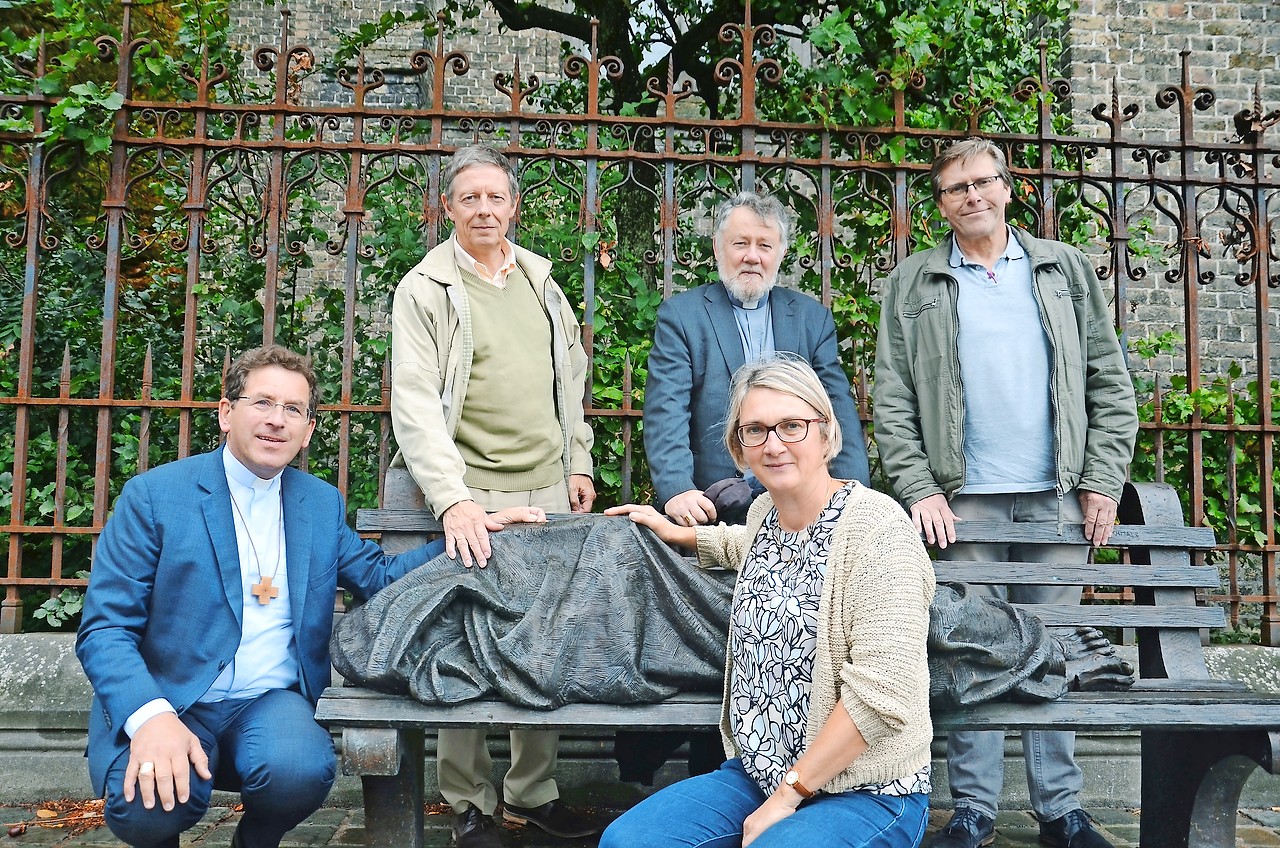 Bisschoppen Lode Aerts (links) en Jean Kockerols (midden) met de JRS-medewerkers bij het beeld Homeless Jesus. © Helen Mardaga