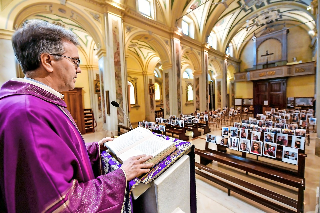 Pastoor Corbari celebreert in Robbiano de eucharistie voor foto’s van zijn parochianen. © Belga Image