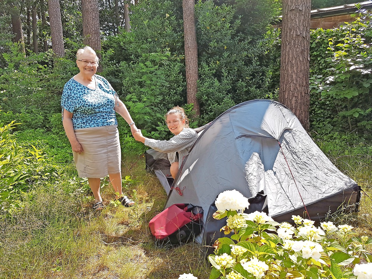 Oma Frieda Goolaerts glundert bij het bezoek van kleindochter Eva Plasschaert, al verblijft ze in haar tent. © Ilse Van Halst