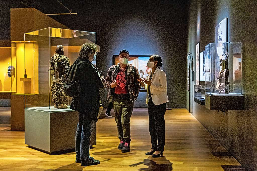 Curator beeldvorming Nadia Nsayi (rechts) bij het krachtbeeld van chef Ne Kuko (in de vitrine links). © Frederik Beyens