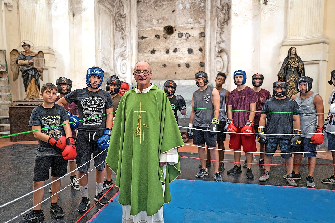 Priester Antonio Loffredo in de boksring die hij in zijn kerk liet installeren. © Roberto Salomone