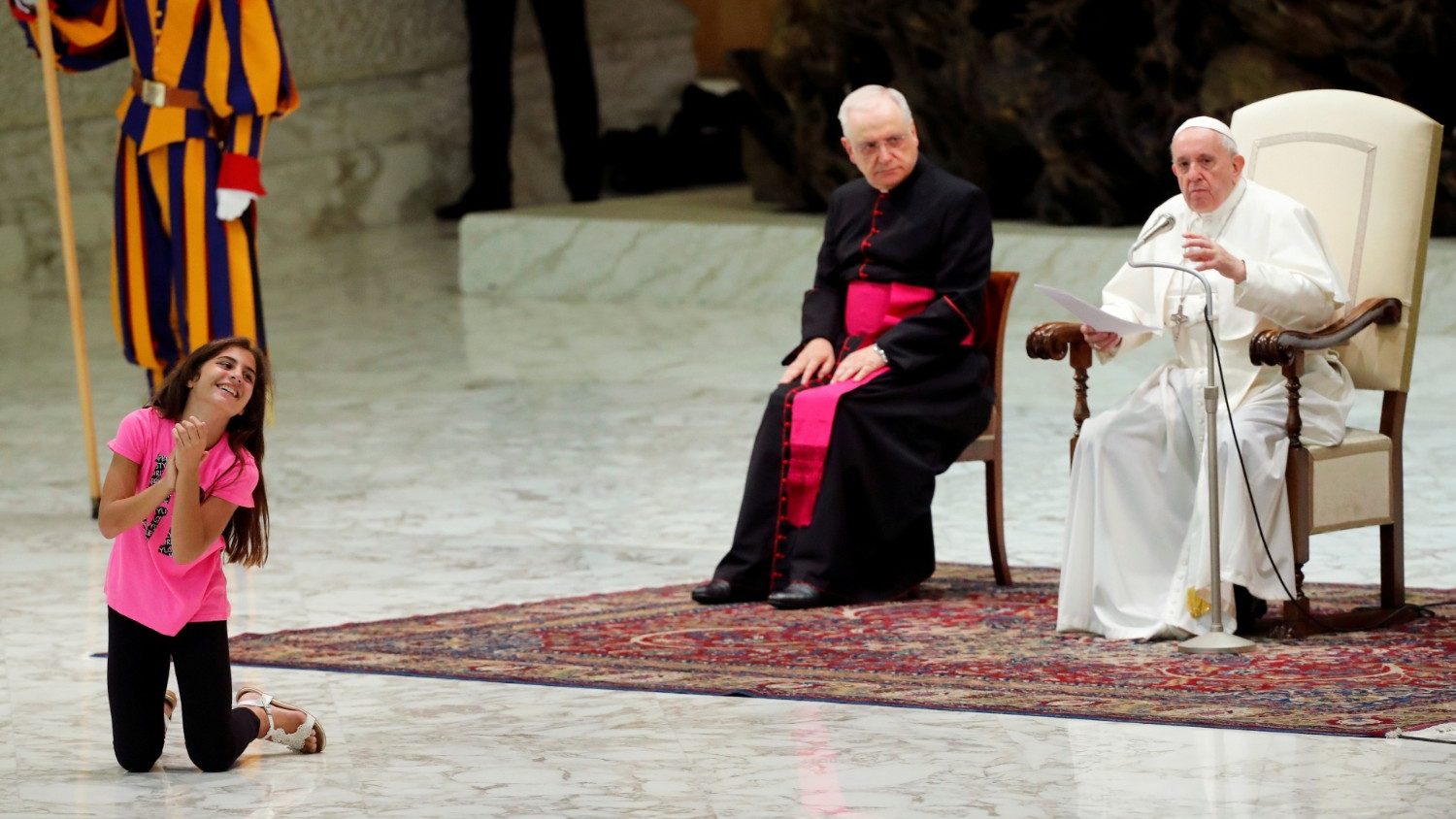 Een argeloos meisje danst tijdens de algemene audiëntie van paus Franciscus op woensdag 21 augustus 2019