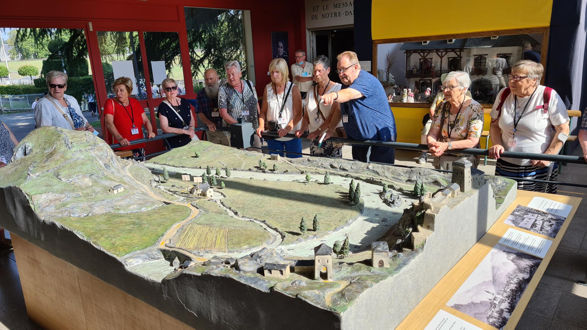 Herman vertelt aan een maquette in Lourdes het verhaal van de sprokkeltochten van Bernadette Soubirous.. 