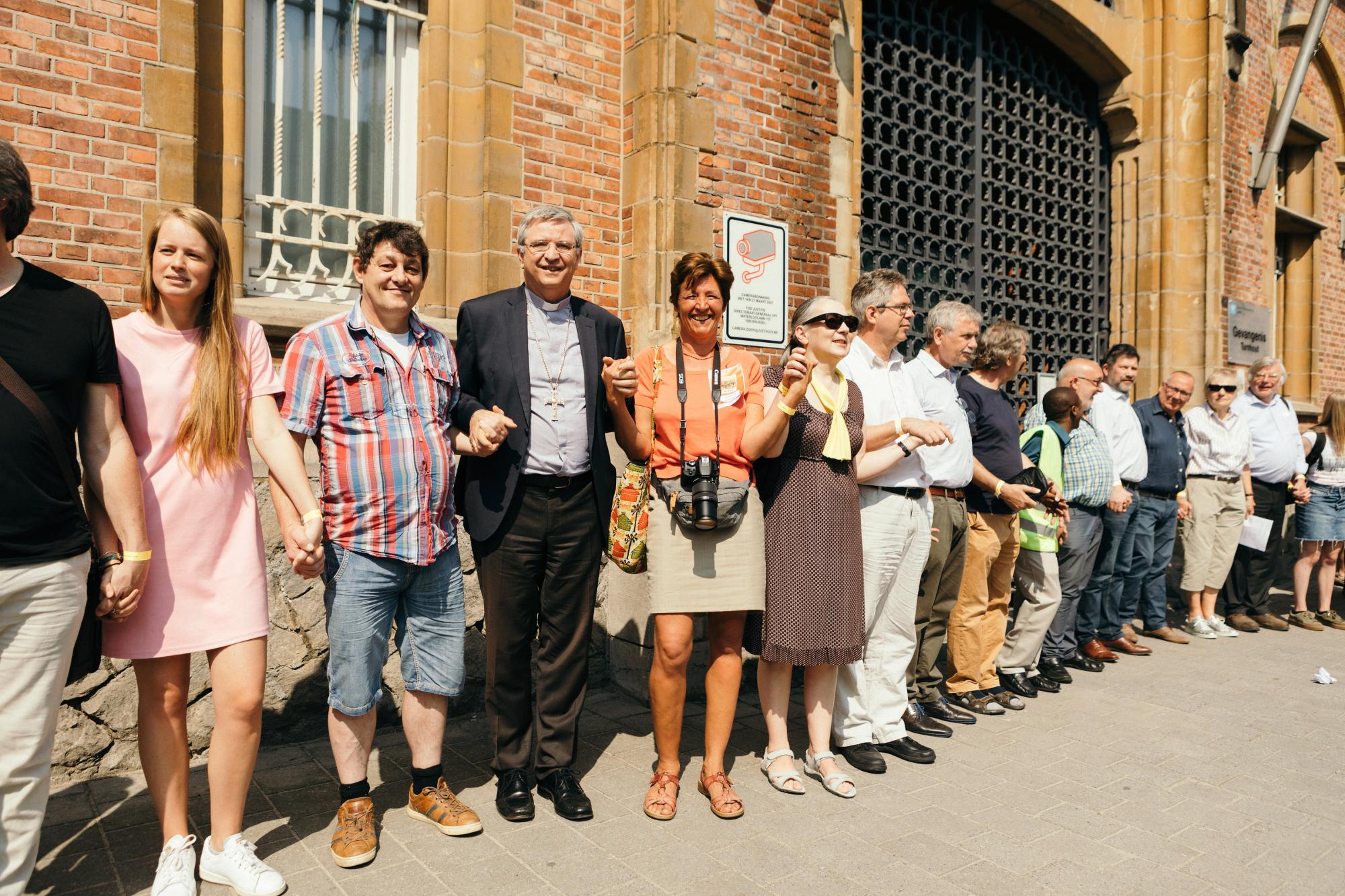 Aalmoezenier Donatienne de Borman en bisschop Bonny omarmen met vele anderen de gevangenis van Turnhout.