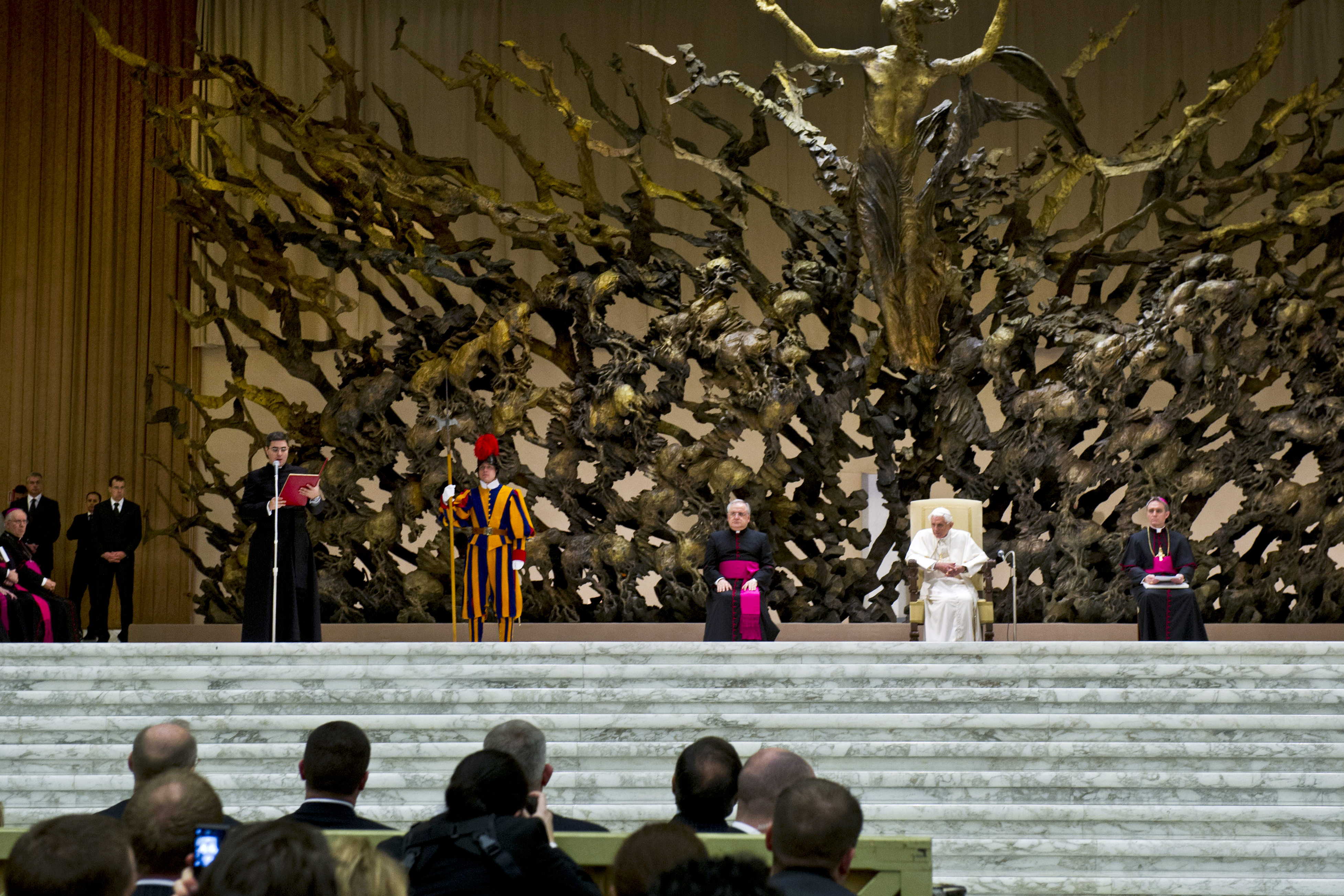 Het sculptuur domineert het podium van de Paulus VI-aula. Hier een foto uit januari 2013 met paus Benedictus XVI. 