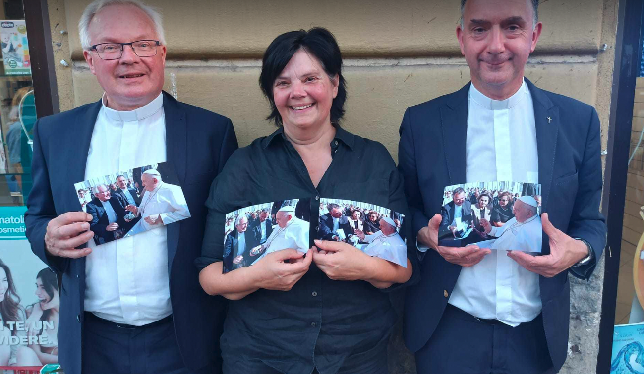 Els De Coker met (links) Peter van der Weide (pastoor van Sneek) en Paul Verbeek (vicaris bisdom Breda) met foto's van de ontmoeting die beiden hadden met de paus.. 